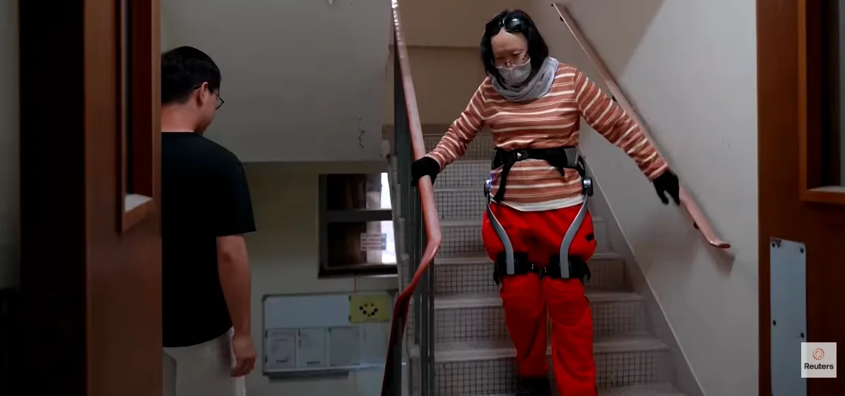 Una persona mayor sube una escalera interior en un bloque residencial de Hong Kong parcialmente dañado por un incendio